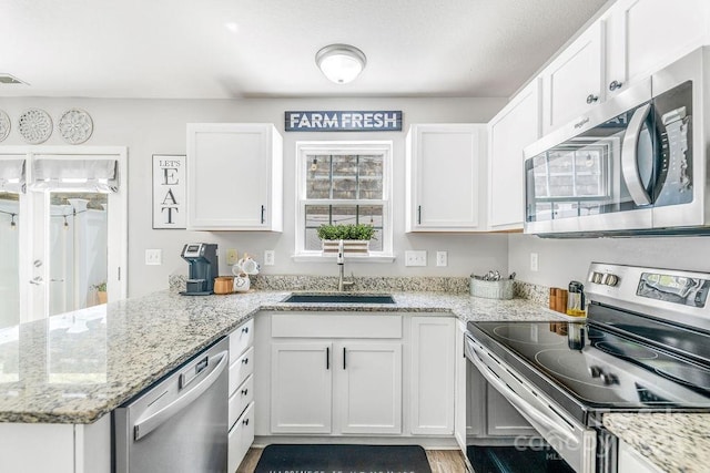 41 Lanceford Cir, Fletcher, NC 28732 - kitchen featuring appliances with stainless steel finishes, a peninsula, white cabinets, a sink, and light stone counters