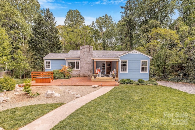 ranch-style house with a chimney, a front yard, and a deck