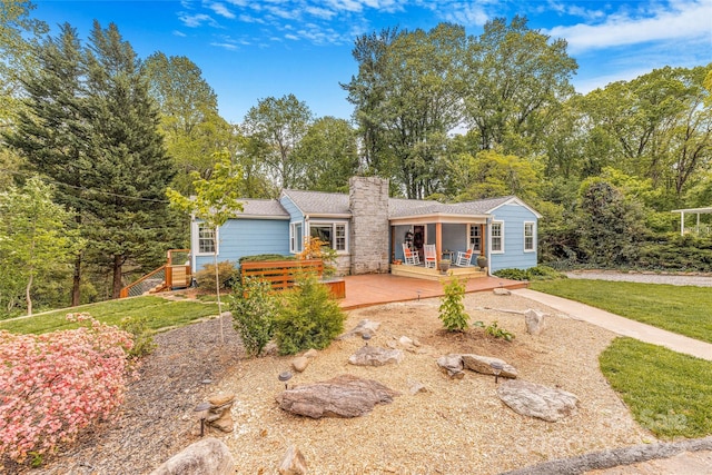 ranch-style house featuring a chimney and a deck