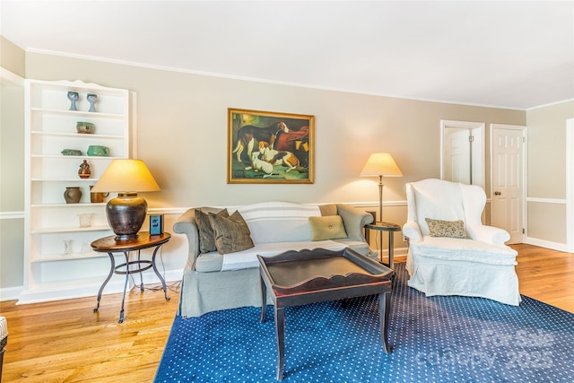 living room with baseboards, ornamental molding, and wood finished floors