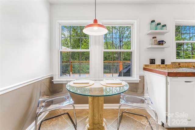 tiled dining area featuring wainscoting