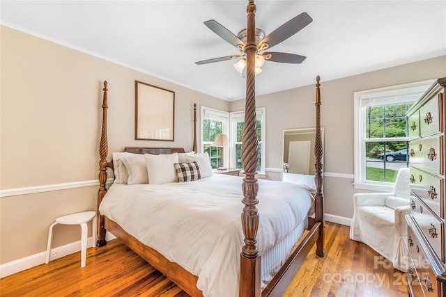 bedroom with ceiling fan, baseboards, and wood finished floors