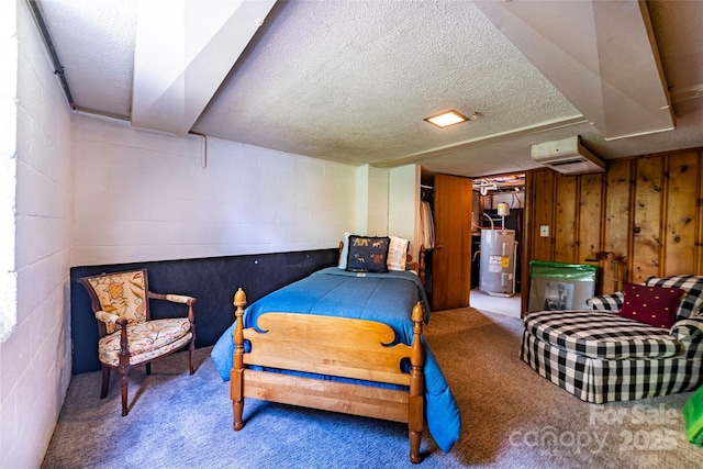 bedroom featuring water heater, a textured ceiling, carpet, and concrete block wall