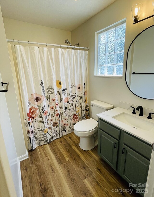full bathroom with vanity, a shower with shower curtain, wood finished floors, and toilet
