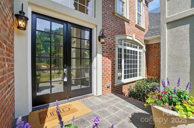 entrance to property with brick siding and french doors