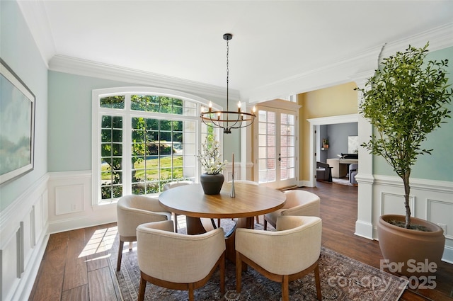 dining area featuring crown molding, plenty of natural light, dark wood-style floors, and a chandelier