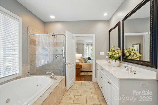 full bath with double vanity, a shower stall, a sink, and a jetted tub