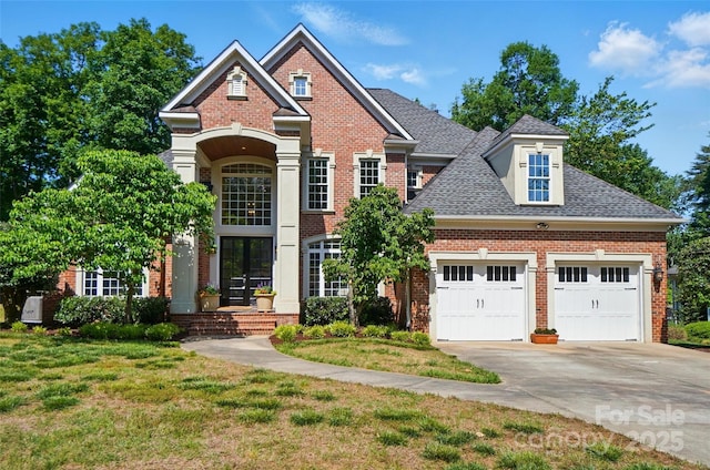 traditional home with roof with shingles, concrete driveway, a front yard, and brick siding