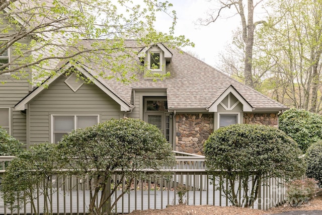 220 Stoney Falls Loop Unit C/2, Burnsville, NC 28714 - view of front facade with roof with shingles, fence, and stone siding