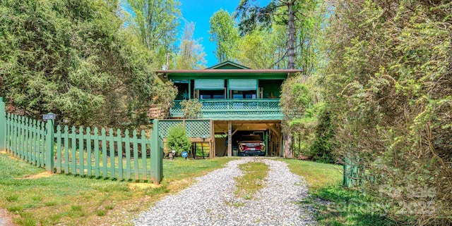 view of front of home featuring fence, driveway, and a carport