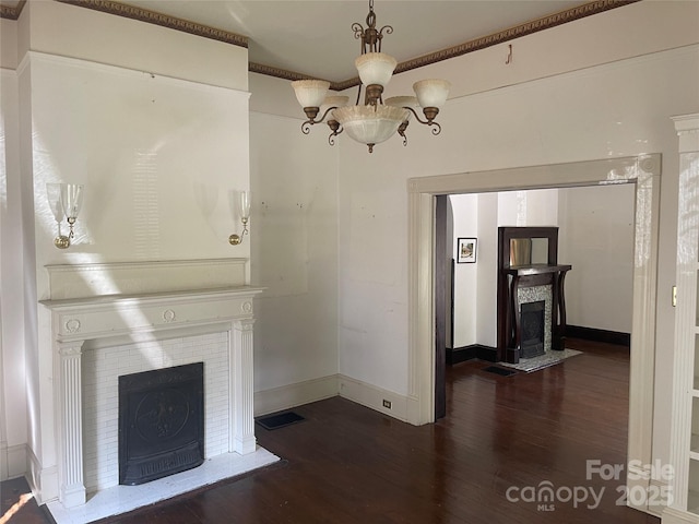 unfurnished living room with a fireplace with flush hearth, wood finished floors, a chandelier, and baseboards