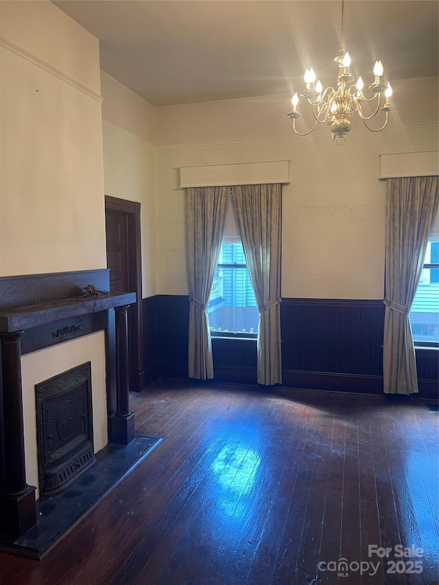 unfurnished living room featuring a wealth of natural light, wainscoting, and hardwood / wood-style flooring