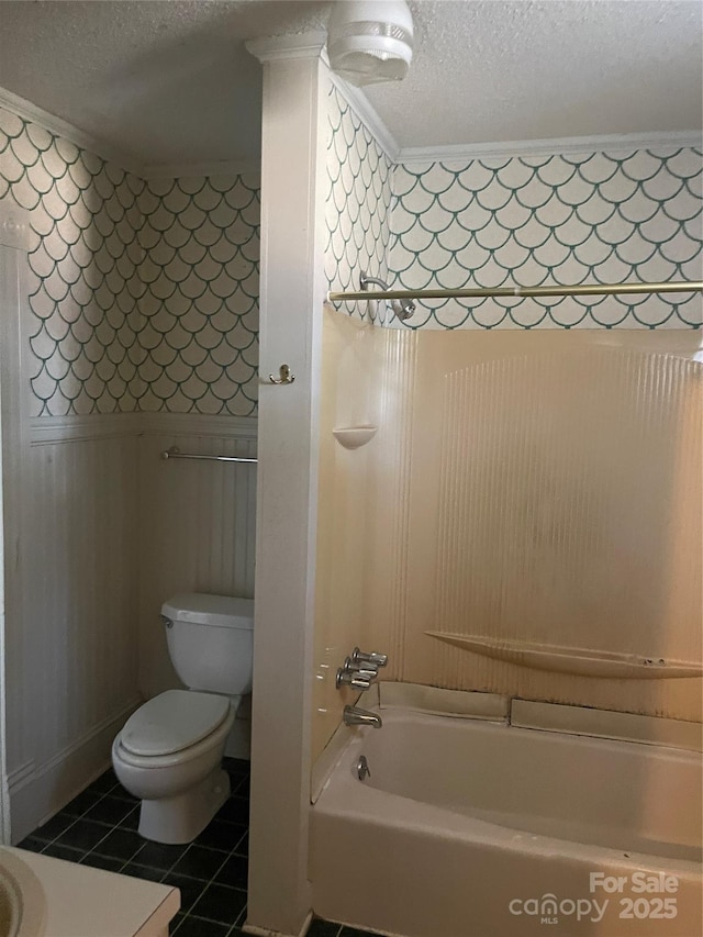 full bath featuring a textured ceiling, toilet, wallpapered walls, wainscoting, and tile patterned flooring