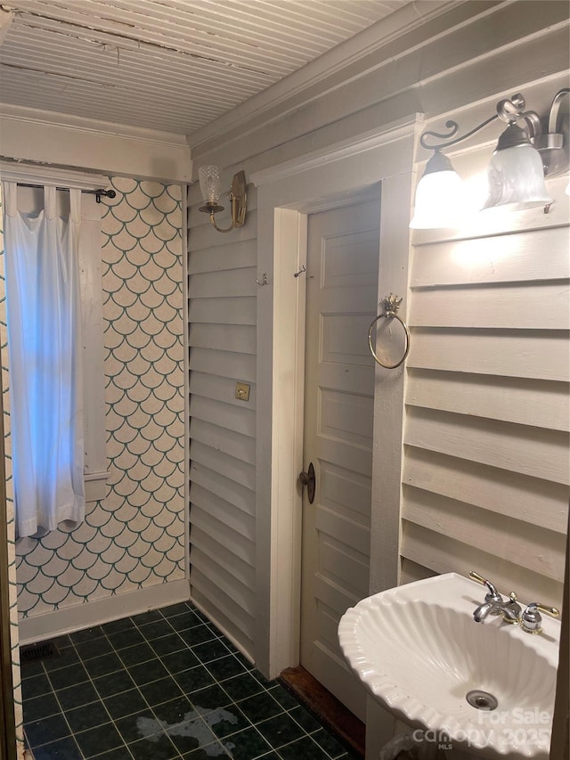 bathroom with crown molding, tile patterned floors, and a sink