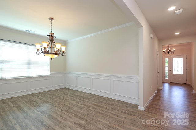 309 Kentmere Ln, Clover, SC 29710 - unfurnished dining area featuring a chandelier, a wainscoted wall, wood finished floors, visible vents, and ornamental molding
