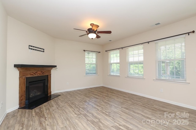 309 Kentmere Ln, Clover, SC 29710 - unfurnished living room with visible vents, a glass covered fireplace, baseboards, ceiling fan, and light wood finished floors