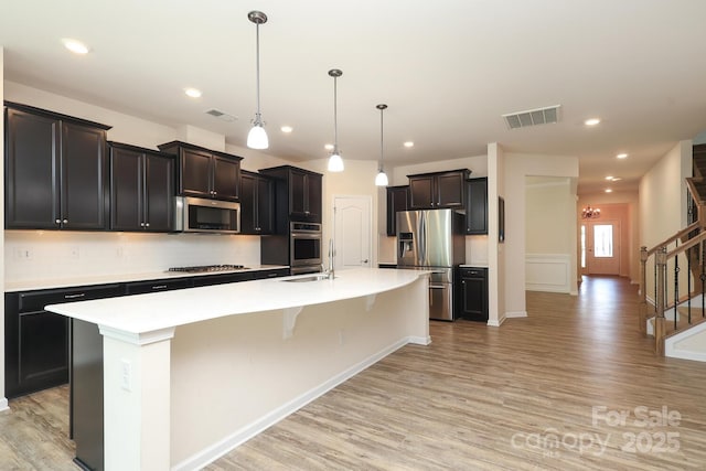 309 Kentmere Ln, Clover, SC 29710 - kitchen featuring appliances with stainless steel finishes, decorative backsplash, visible vents, and light wood-type flooring
