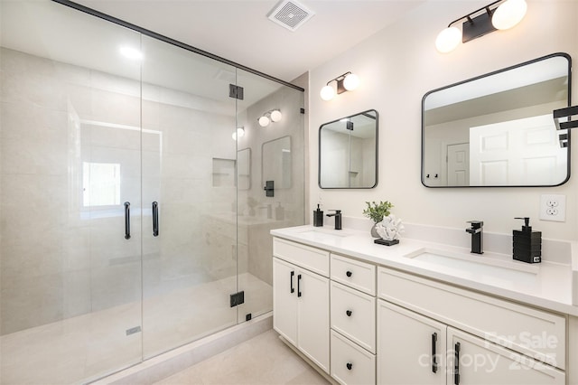 full bathroom featuring visible vents, a sink, a stall shower, and double vanity