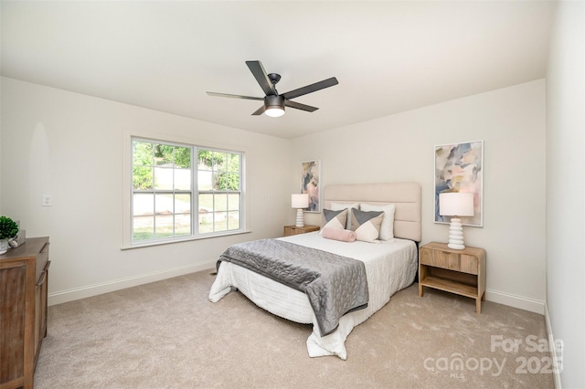 bedroom featuring baseboards, ceiling fan, and light carpet
