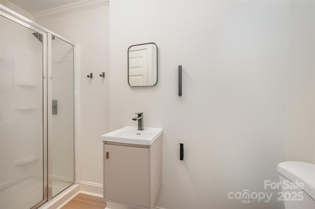 full bathroom with crown molding, a stall shower, toilet, and vanity