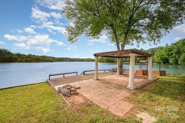 view of dock with a water view and a yard