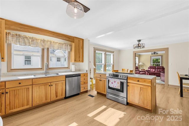 1104 Venus St, Kannapolis, NC 28083 - kitchen featuring stainless steel appliances, a sink, light wood-style floors, light countertops, and a chandelier