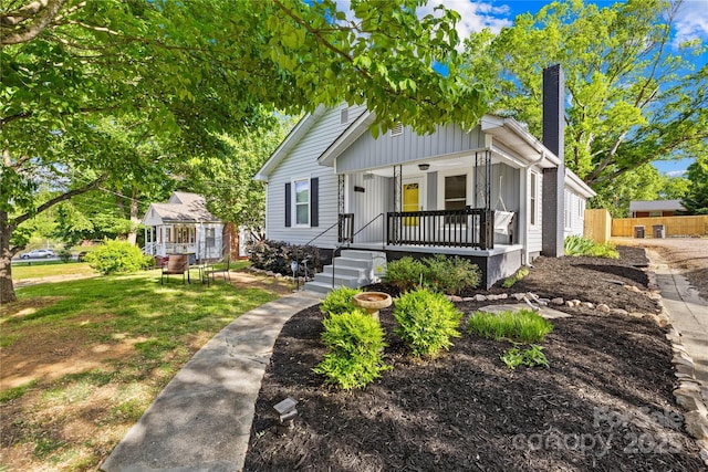 1104 Venus St, Kannapolis, NC 28083 - bungalow featuring covered porch, a chimney, board and batten siding, and fence