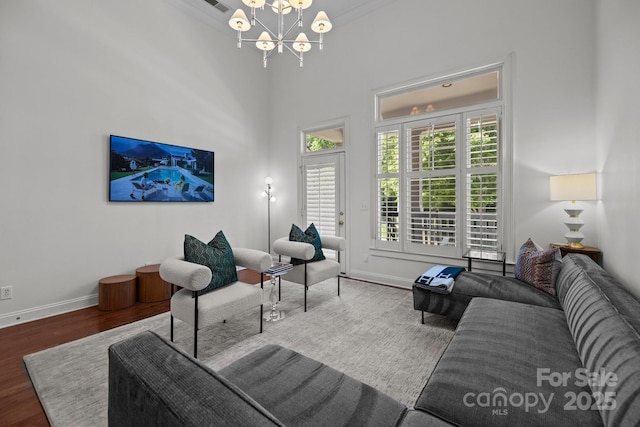 living area featuring baseboards, an inviting chandelier, and wood finished floors