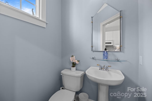 half bath featuring a sink and toilet
