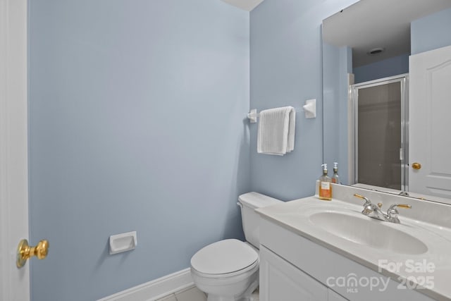 bathroom with toilet, baseboards, a shower stall, tile patterned flooring, and vanity