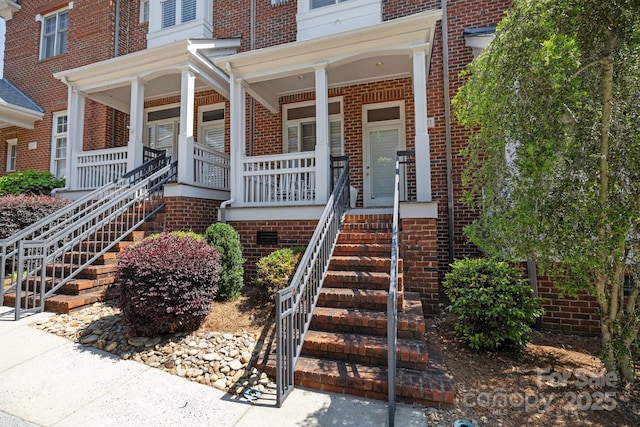 property entrance featuring brick siding and a porch