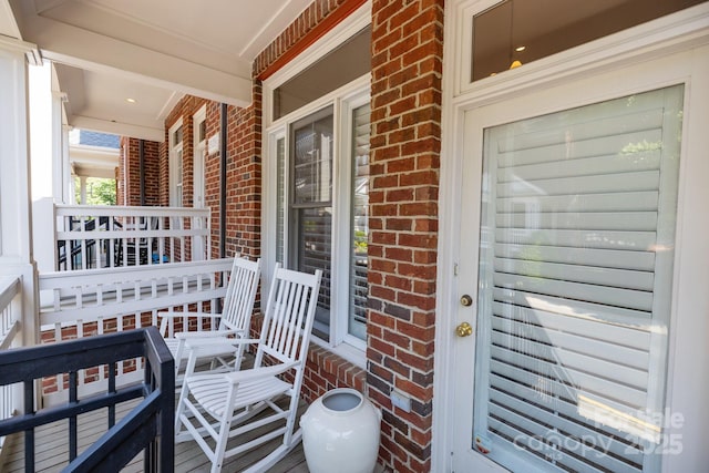 entrance to property with brick siding and a porch