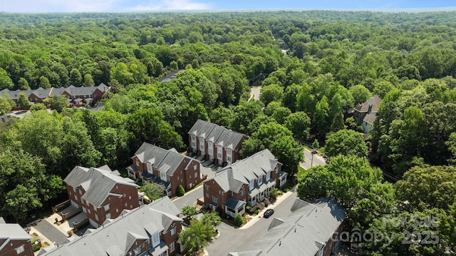 drone / aerial view featuring a forest view and a residential view