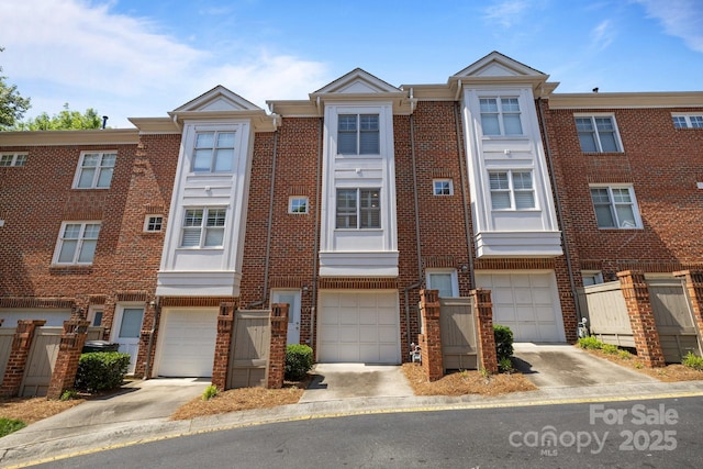 multi unit property with a garage, brick siding, and driveway