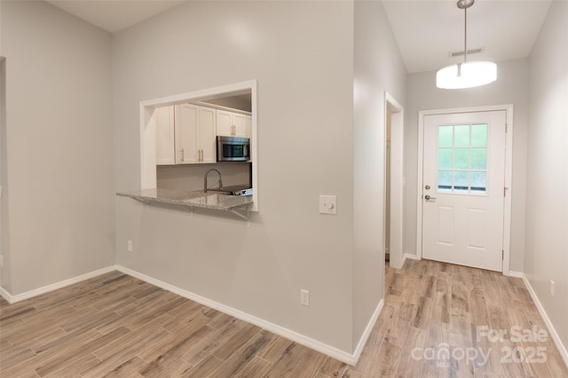 entryway featuring visible vents, light wood finished floors, and baseboards