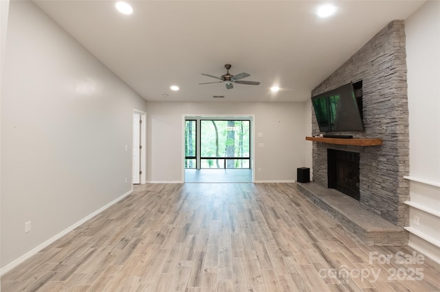 unfurnished living room with light wood-type flooring, recessed lighting, ceiling fan, and a stone fireplace