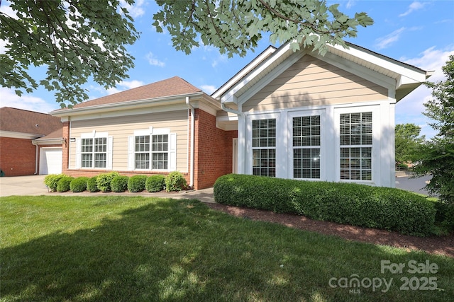 2114 N Castle Ct, Matthews, NC 28105 - ranch-style house with a front yard, brick siding, a garage, and driveway