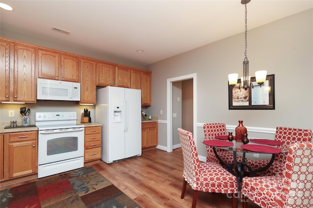 2114 N Castle Ct, Matthews, NC 28105 - kitchen with an inviting chandelier, light wood-style flooring, visible vents, white appliances, and light countertops