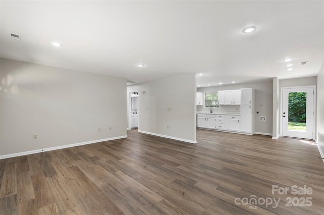 7525 Cedarbrook Dr, Charlotte, NC 28215 - unfurnished living room featuring baseboards, dark wood-style flooring, recessed lighting, and visible vents