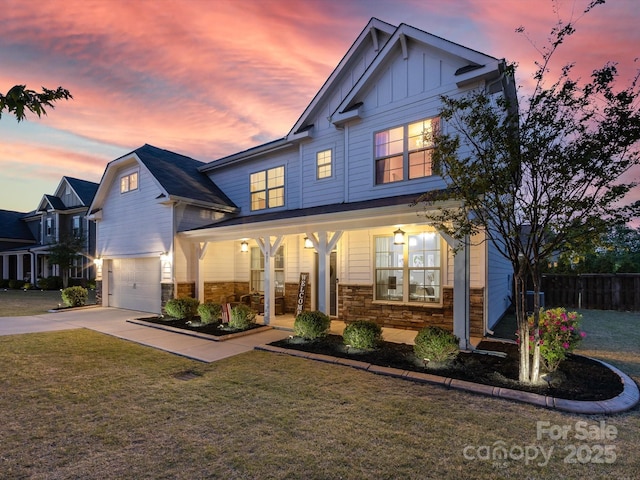 view of front of property with fence, an attached garage, board and batten siding, a porch, and a lawn