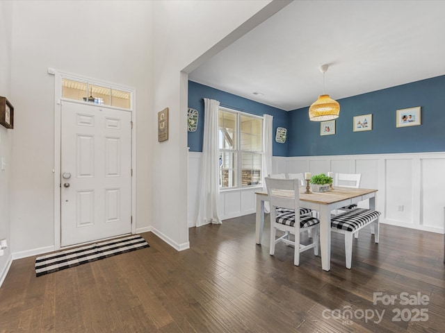 entryway featuring a decorative wall, wood finished floors, and a wainscoted wall