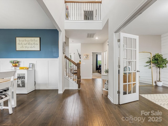 foyer with visible vents, stairs, and hardwood / wood-style flooring