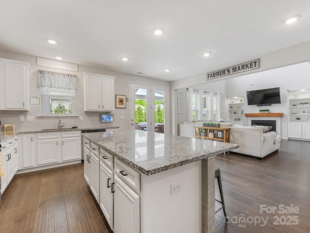 kitchen with plenty of natural light, a sink, white cabinetry, and dark wood-style floors