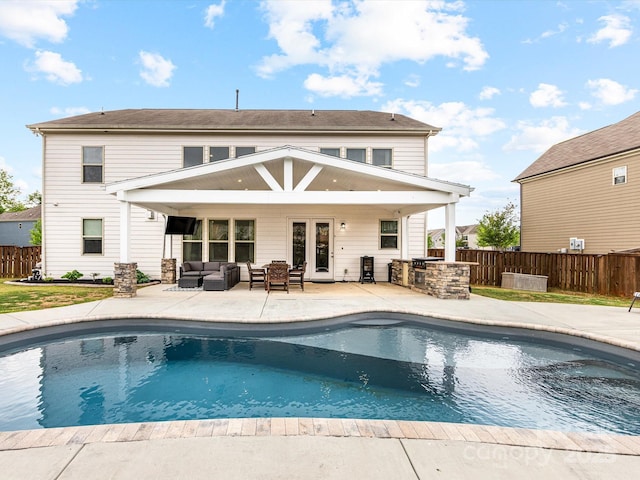 rear view of house with a fenced in pool, outdoor lounge area, fence, and a patio area