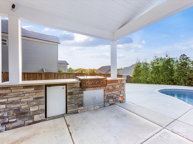 view of patio featuring an outdoor kitchen and an outdoor pool