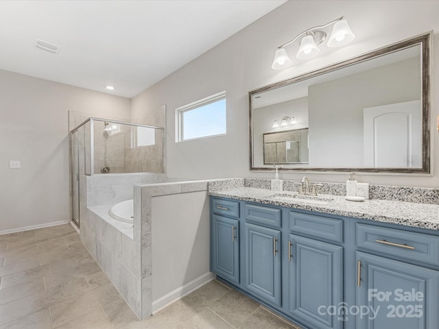 bathroom featuring vanity, a bath, baseboards, and a stall shower