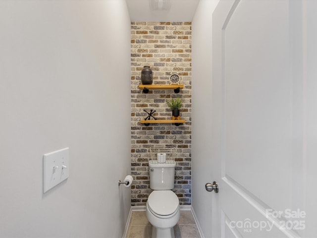 bathroom with toilet, tile patterned floors, and baseboards