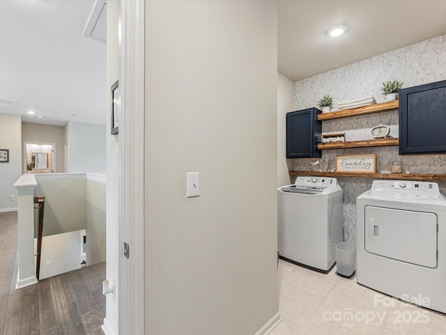 laundry room featuring attic access, cabinet space, baseboards, separate washer and dryer, and light wood-style flooring