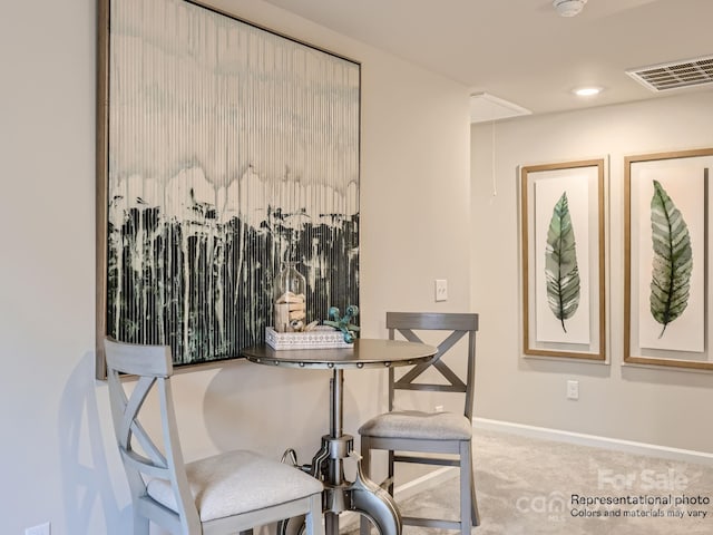 carpeted dining room featuring visible vents, attic access, and baseboards