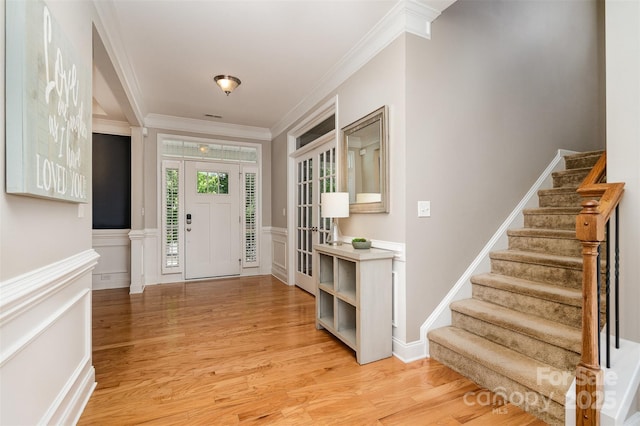 15807 Foreleigh Rd, Huntersville, NC 28078 - entryway with stairs, ornamental molding, light wood-type flooring, wainscoting, and a decorative wall